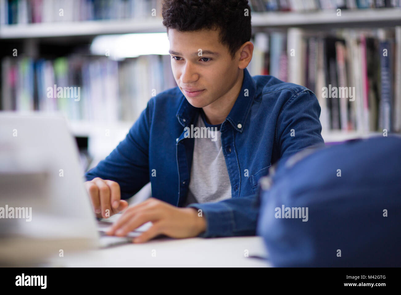 Schüler arbeiten am Laptop in der Bibliothek Stockfoto