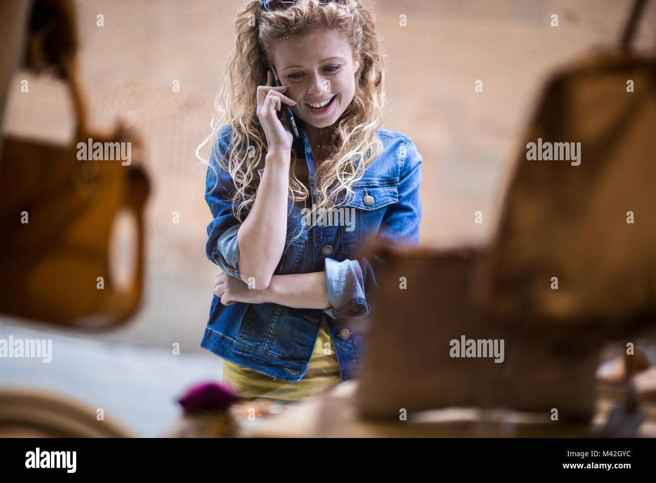 Junge weibliche Window Shopping und auf dem Telefon Stockfoto