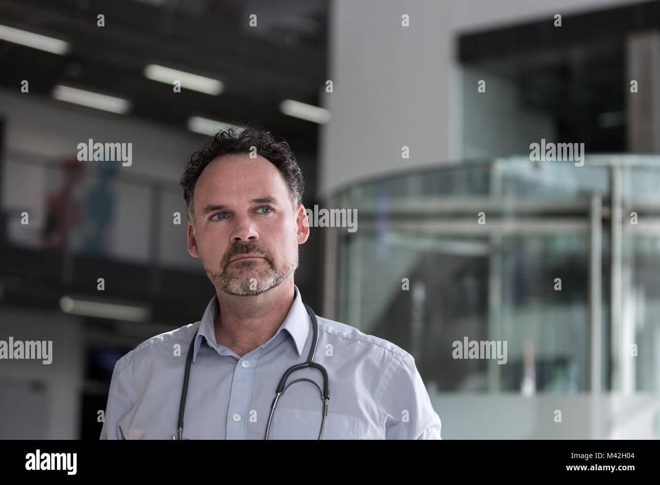 Portrait von männlicher Arzt gehen durch Krankenhaus Stockfoto