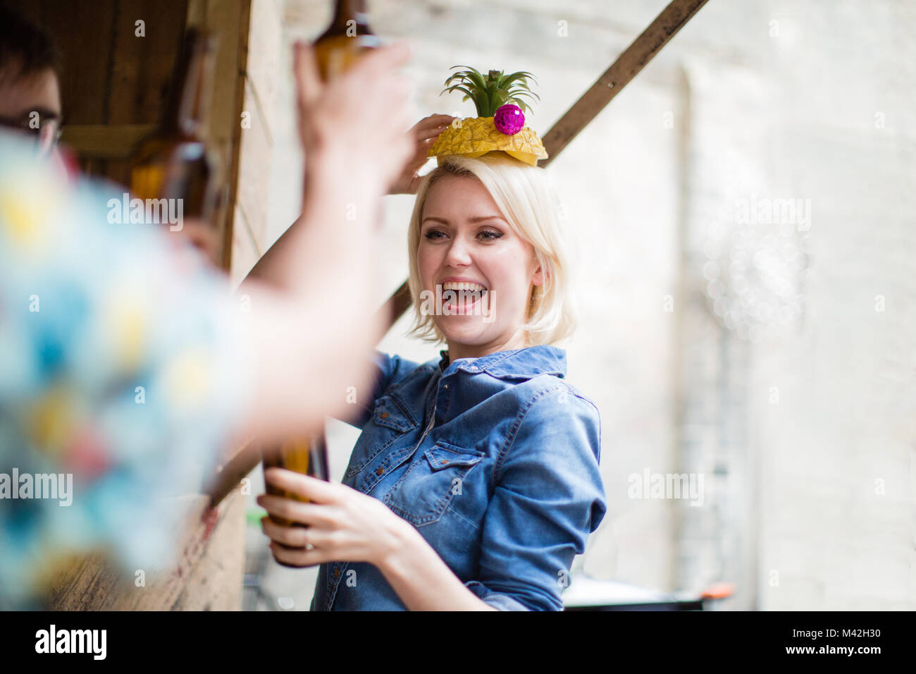 Junge erwachsene Frauen mit einer Ananas auf den Kopf stellen Stockfoto