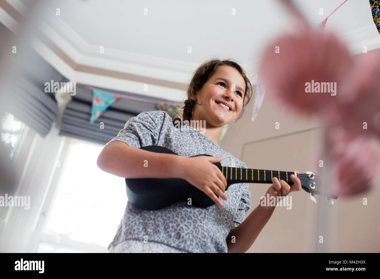 Mädchen spielen eine ukulele Stockfoto