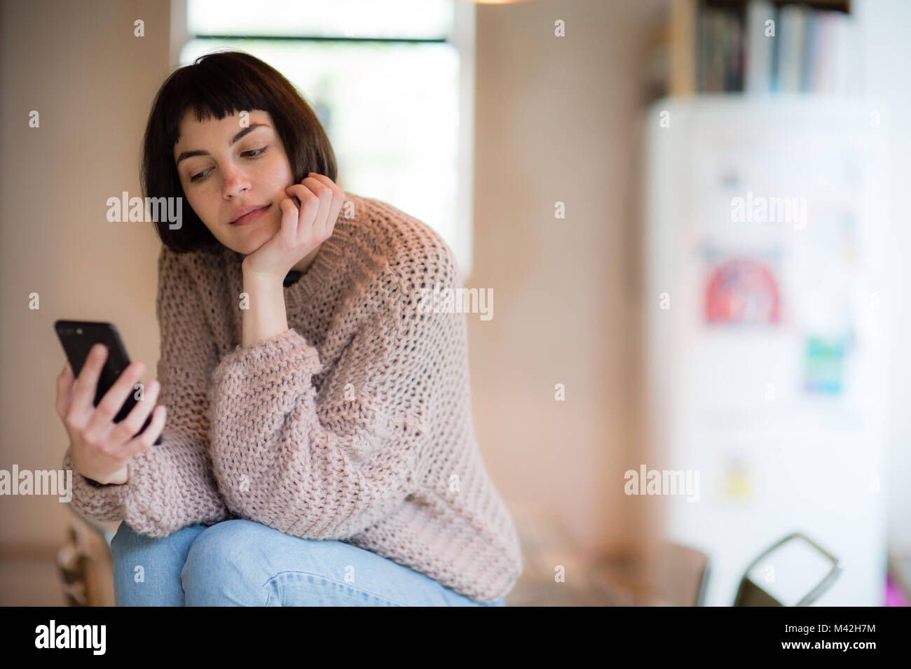 Junge erwachsene Frau ihr Smartphone prüfen Stockfoto