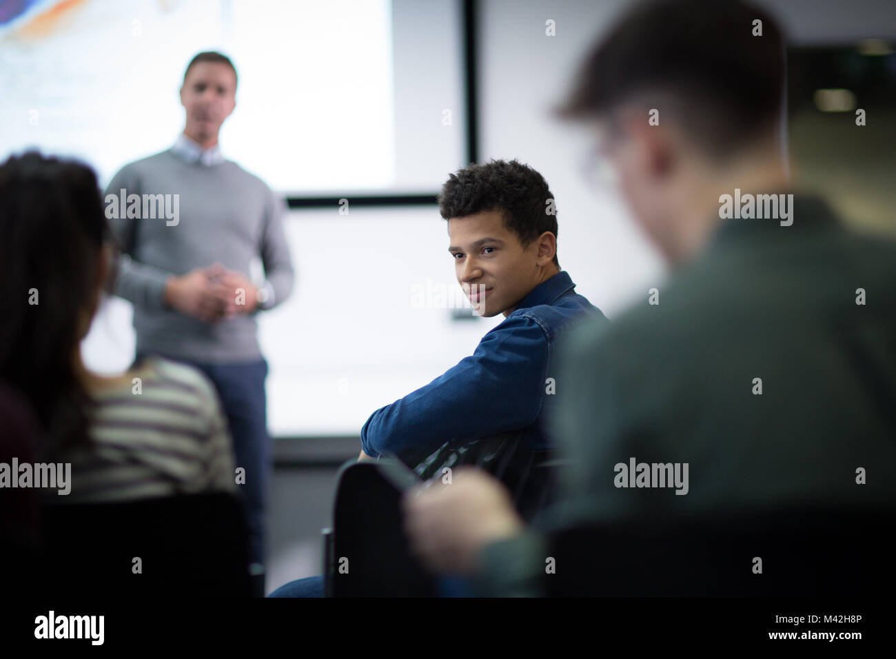 Schüler hören auf eine Frage bei einem Vortrag Stockfoto