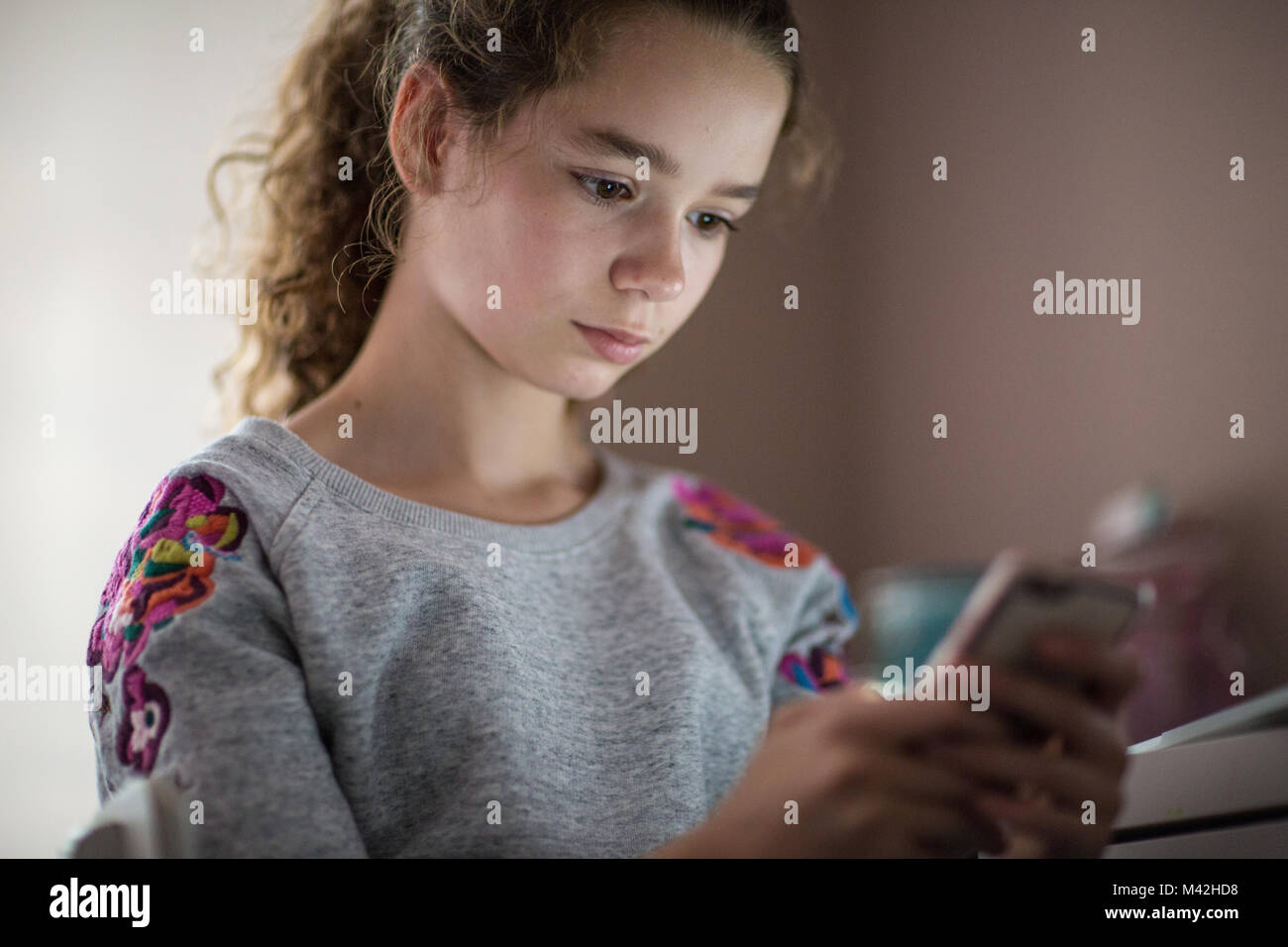 Teenager im Schlafzimmer Blick auf Smartphone Stockfoto