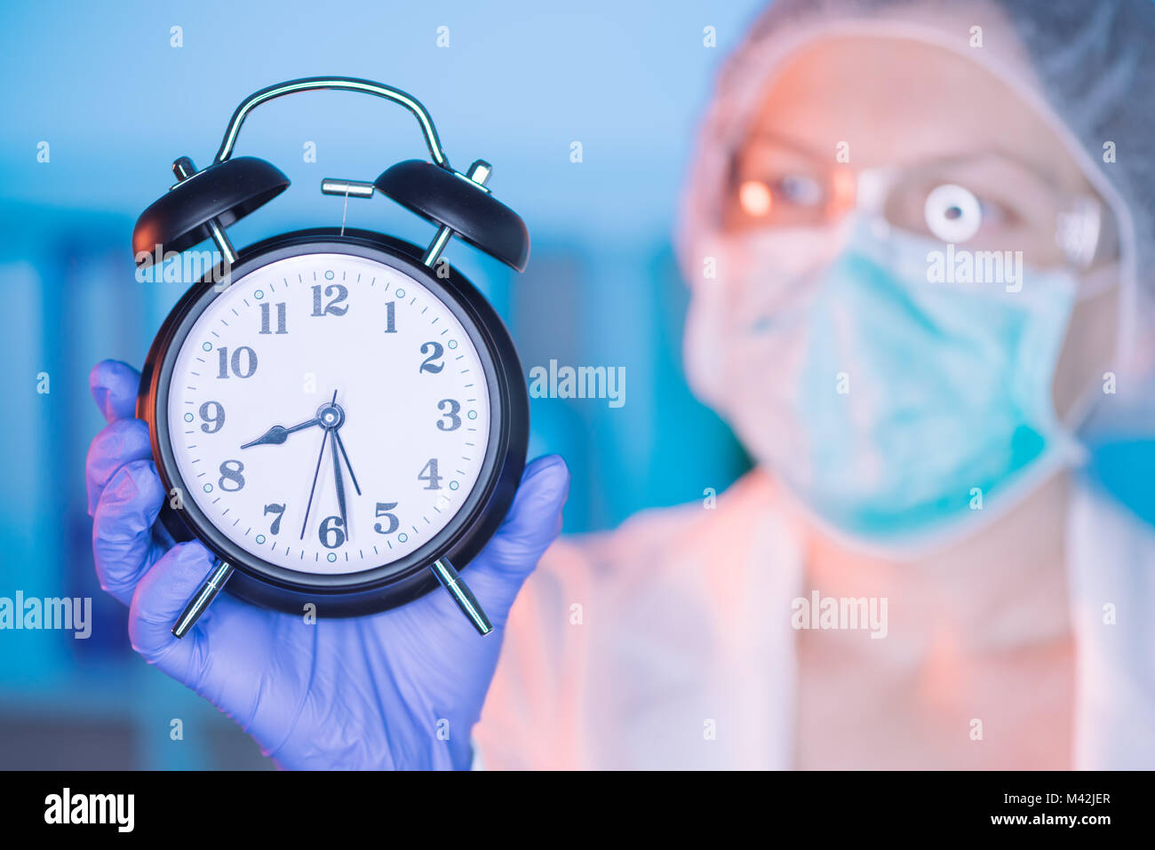 Weibliche Chirurg Facharzt mit Uhr unterstreicht die Bedeutung der regelmäßigen medizinischen Untersuchungen Stockfoto