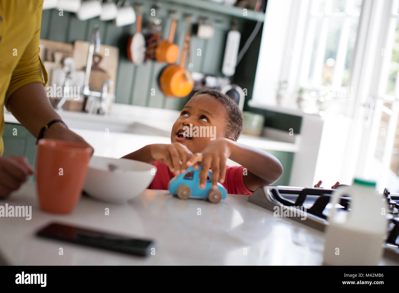 Junge spielt beim Frühstück Stockfoto
