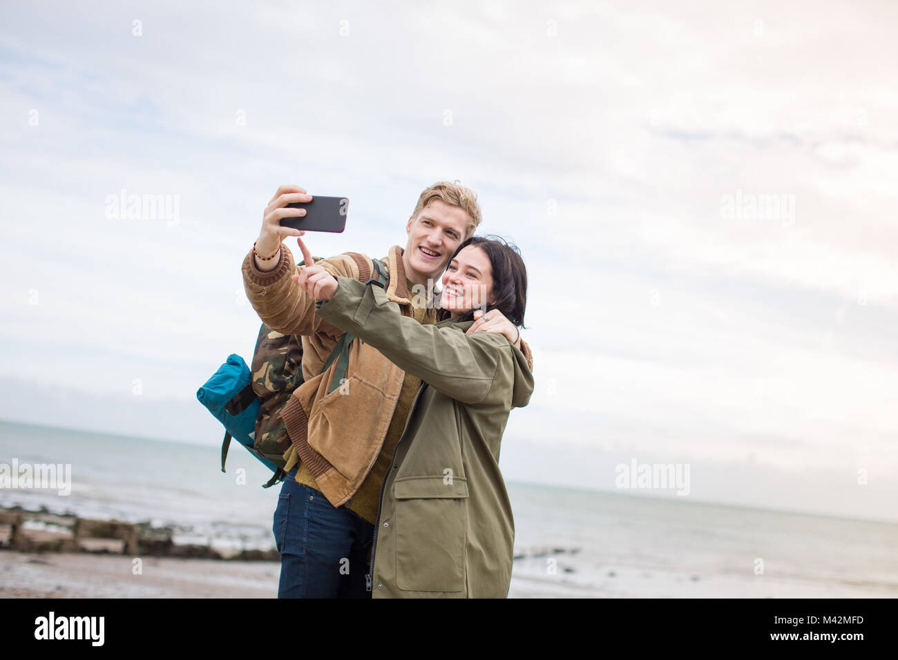 Junges Paar ein selfie am Strand im Winter Stockfoto
