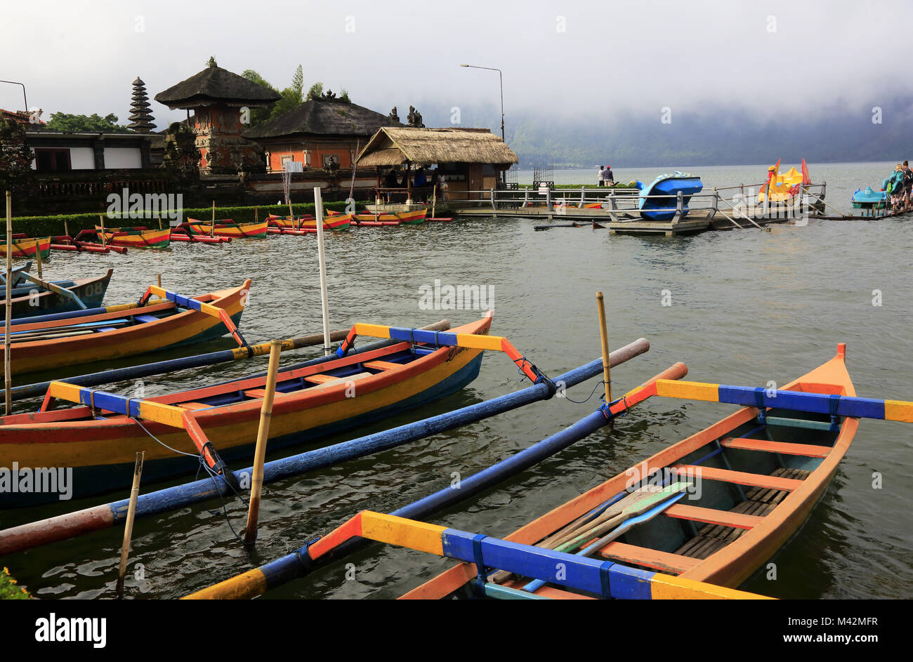 Jukungs die traditionellen Balinesischen Fischerbooten am Ufer des Lake Bratan mit Pura Ulun Danu Bratan Tempel im Hintergrund. Bali Indonesien Stockfoto