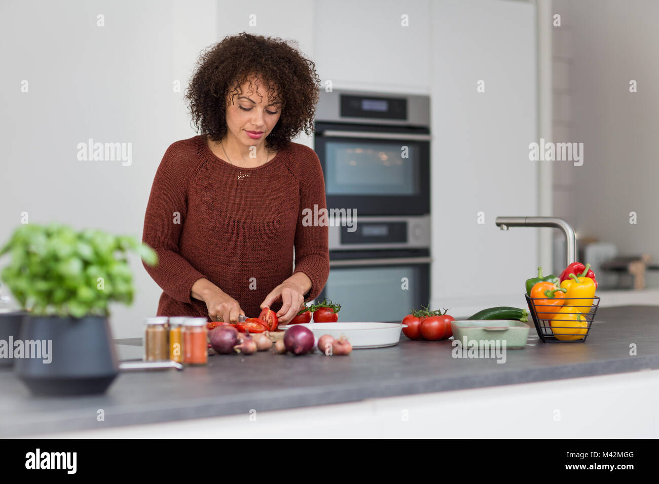 Afrikanische amerikanische weibliche hacken Tomaten Stockfoto
