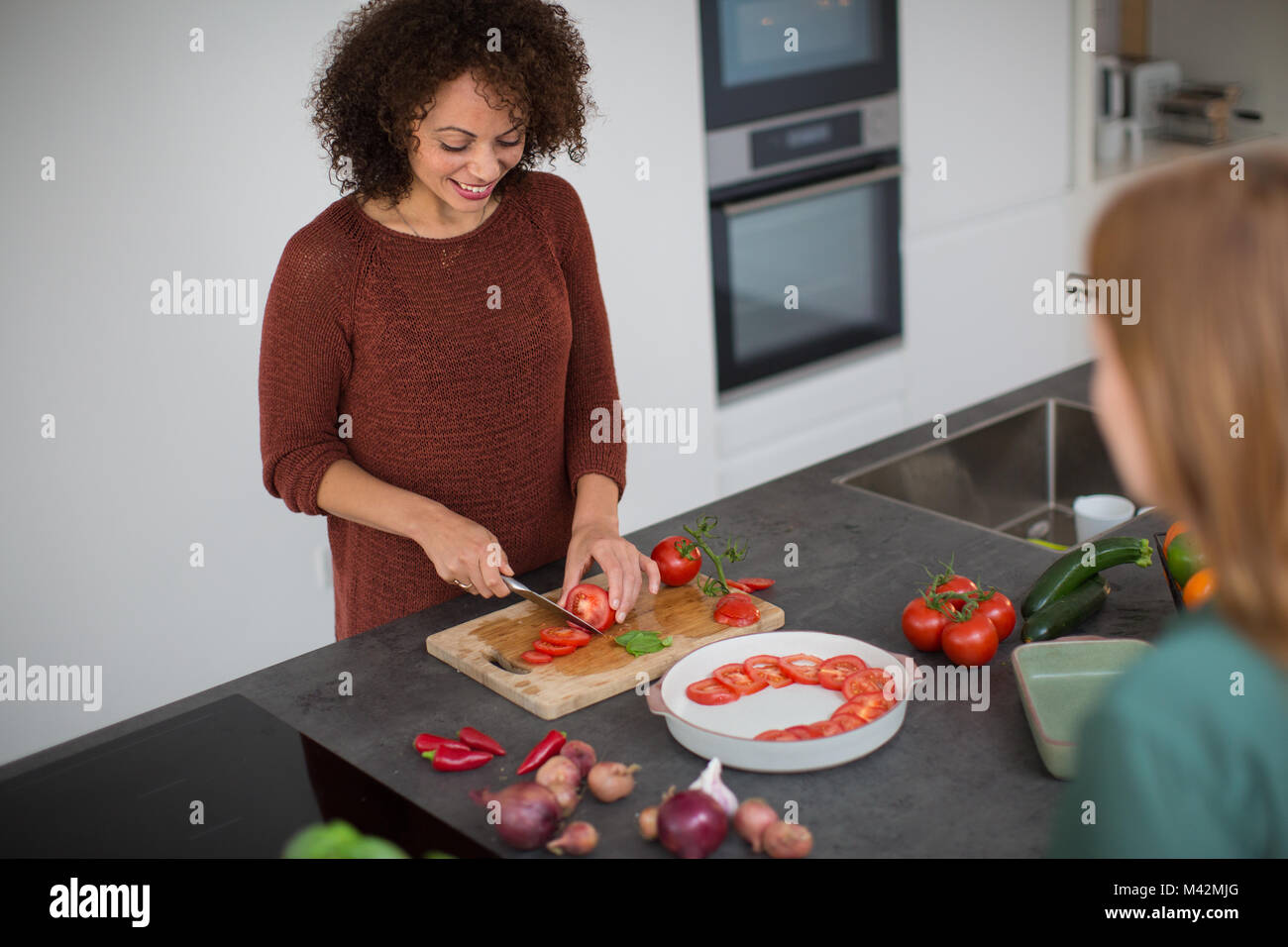 Afrikanische amerikanische weibliche Vorbereitung Mahlzeit für einen Freund Stockfoto