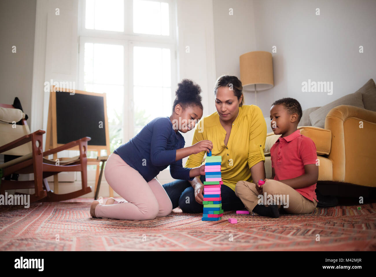 Mutter mit Kinder bauen einen Turm Stockfoto