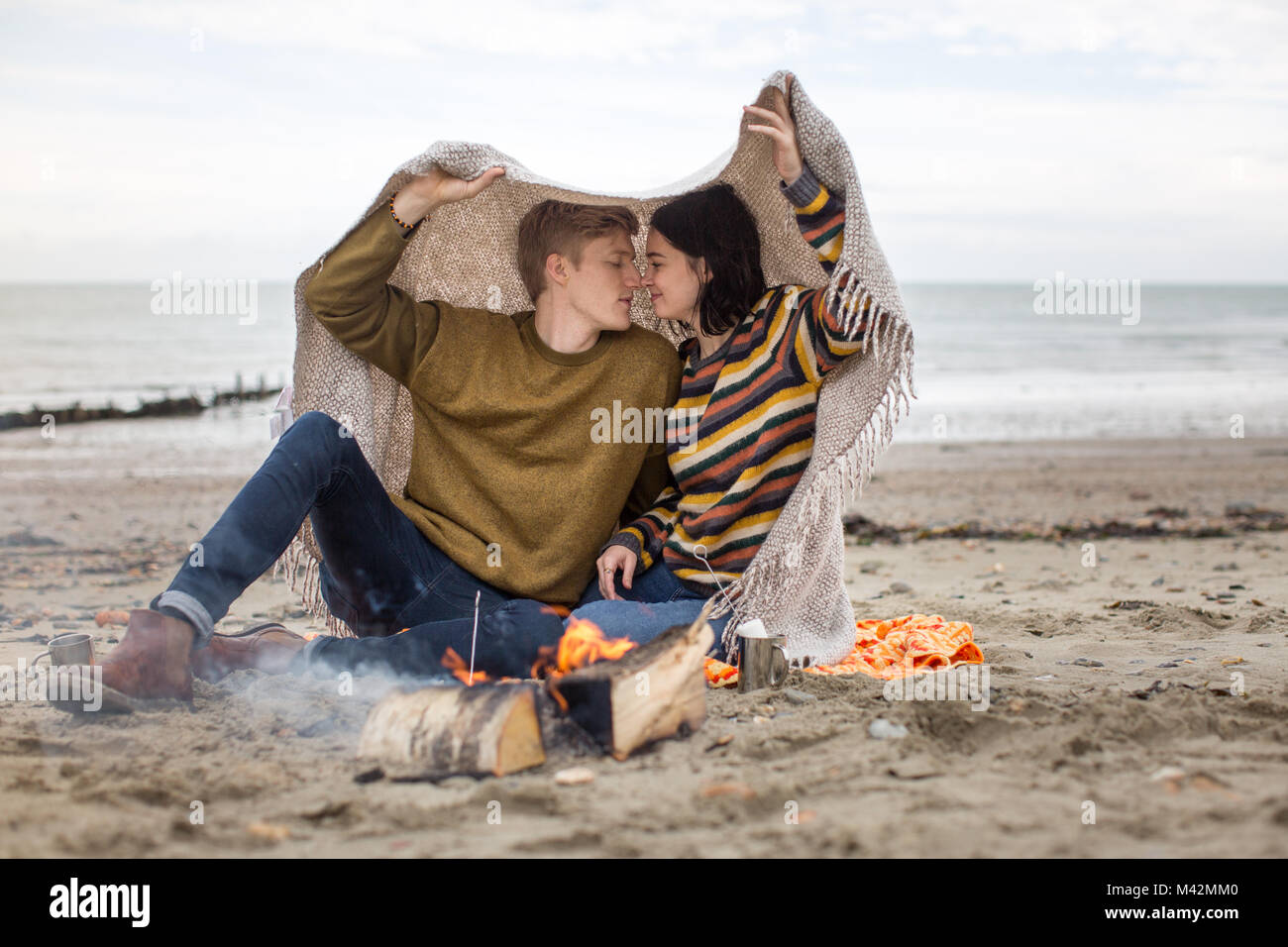 Junges Paar küssen unter einer Decke Stockfoto