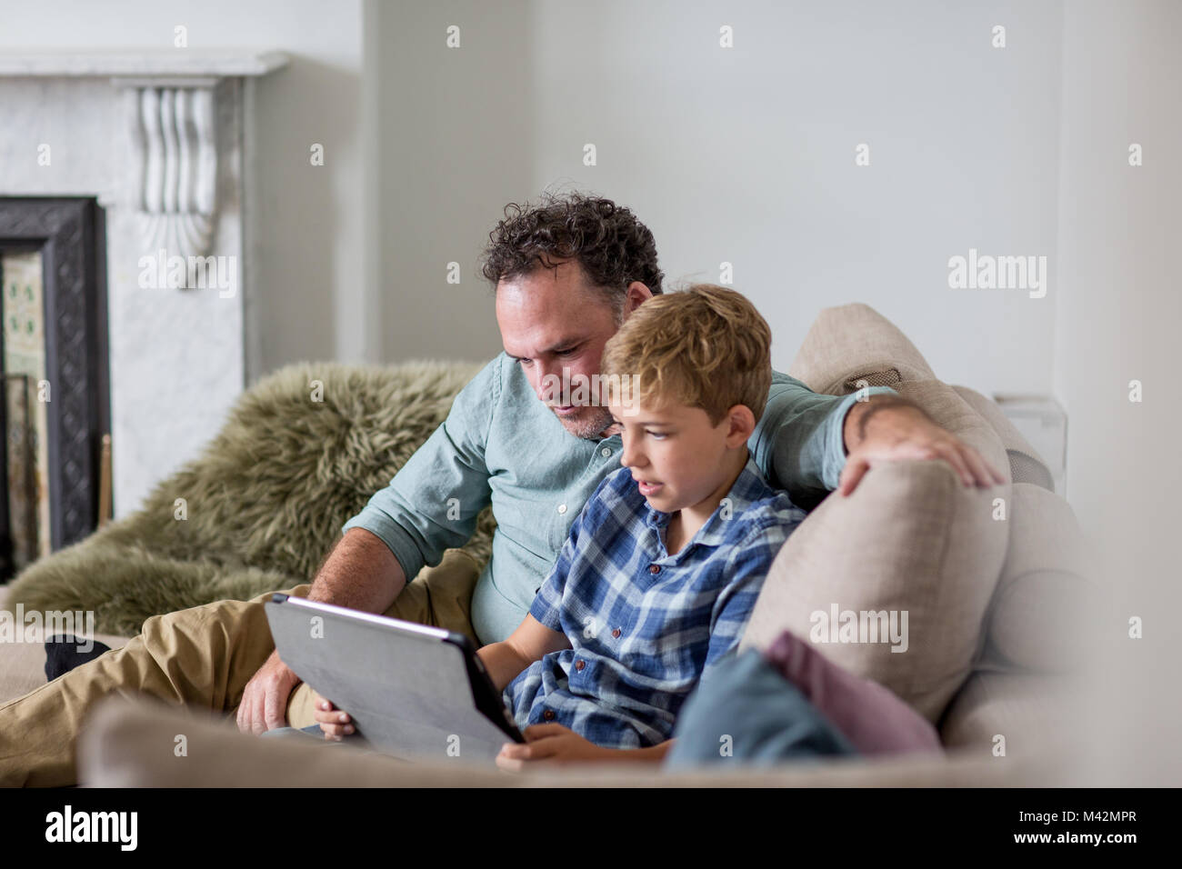Vater und Sohn auf der Suche an einem digitalen Tablet Stockfoto