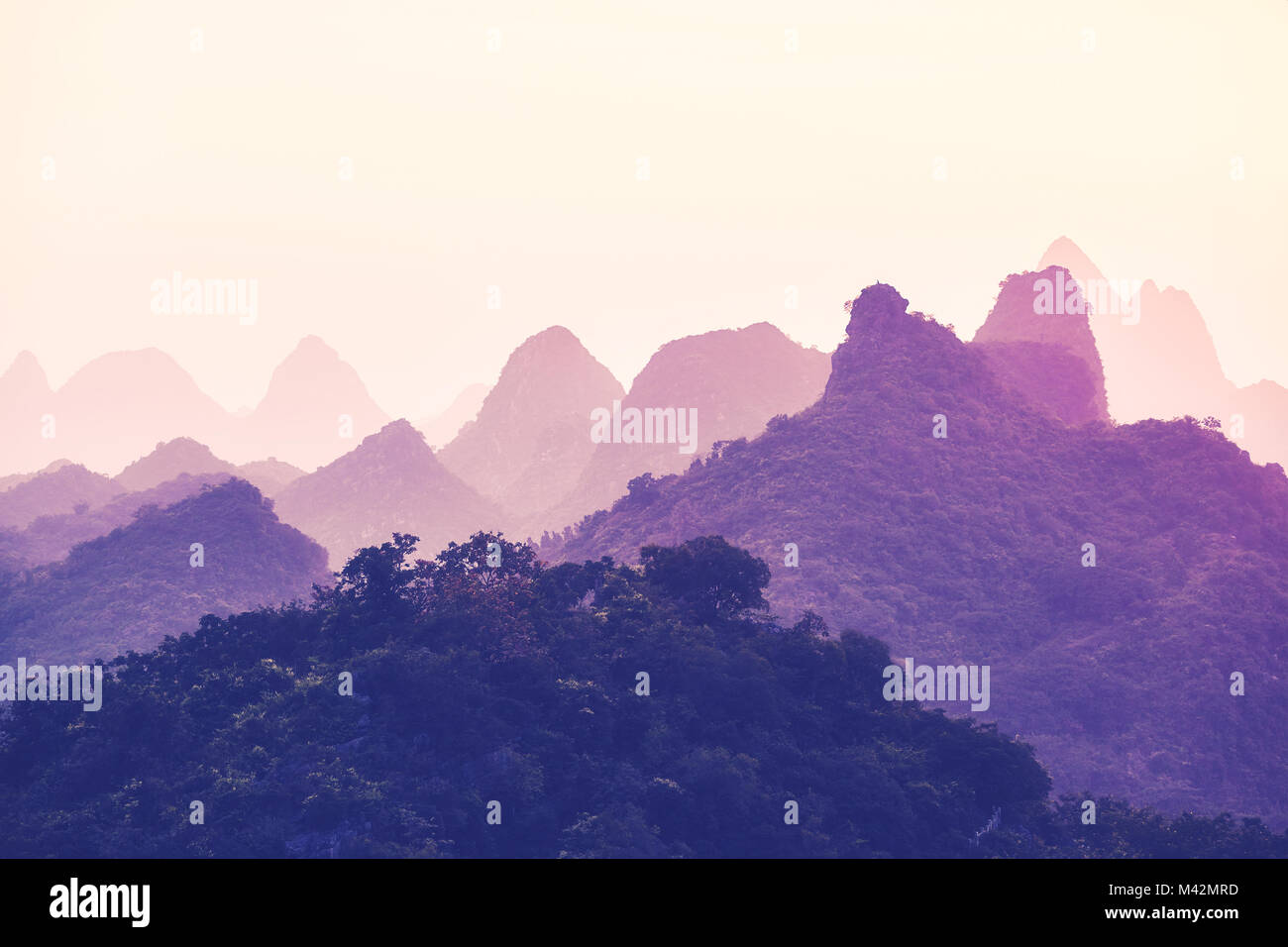 Einen malerischen Sonnenuntergang über Karstgebirge in Guilin, China, einem der beliebtesten Reiseziele. Farbe getonte Bild. Stockfoto