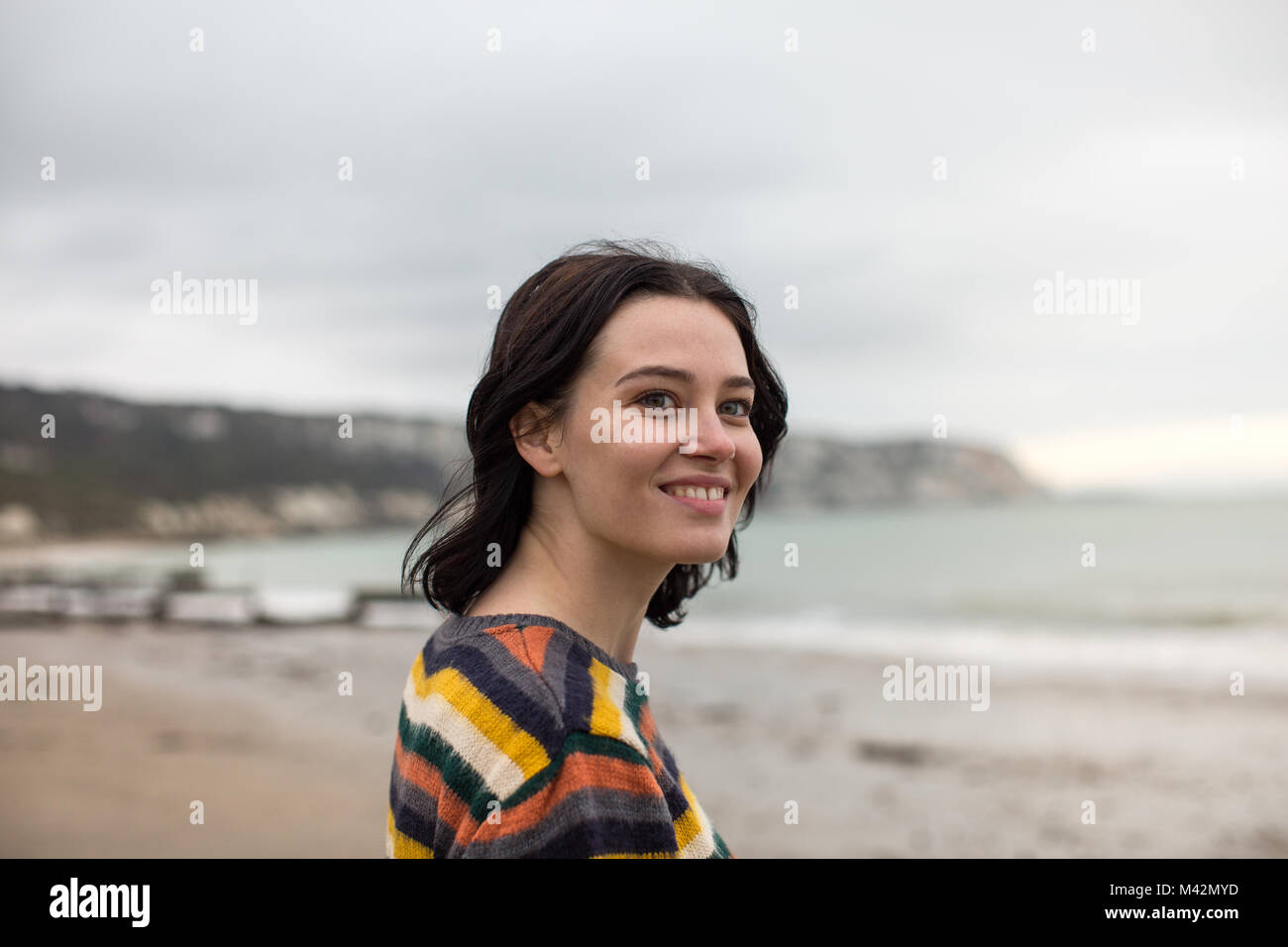 Glückliche junge Frau auf ein Winter Beach Break Stockfoto