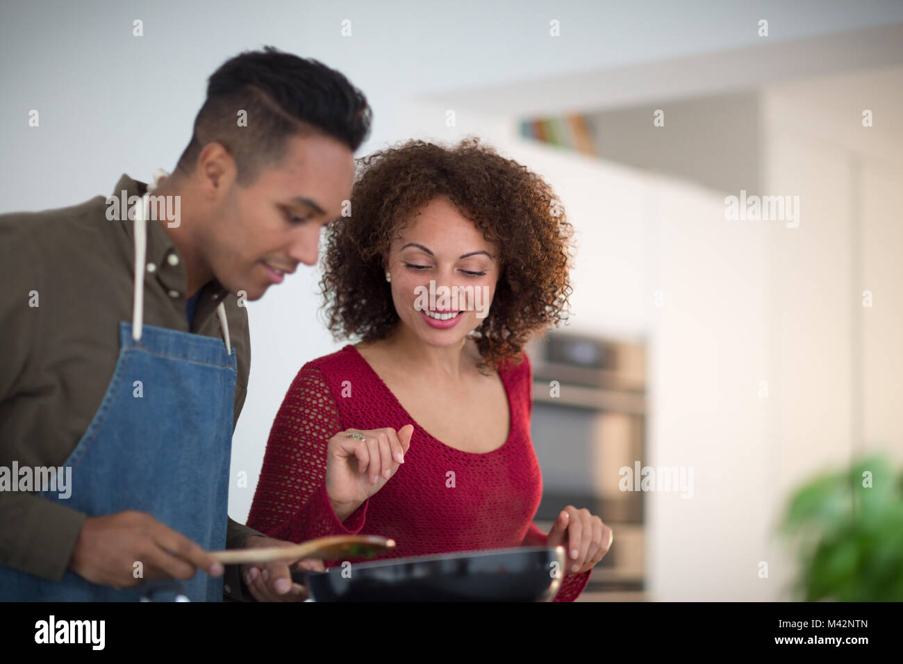 Erwachsene männliche Vorbereitung Abendessen für Freundin Stockfoto