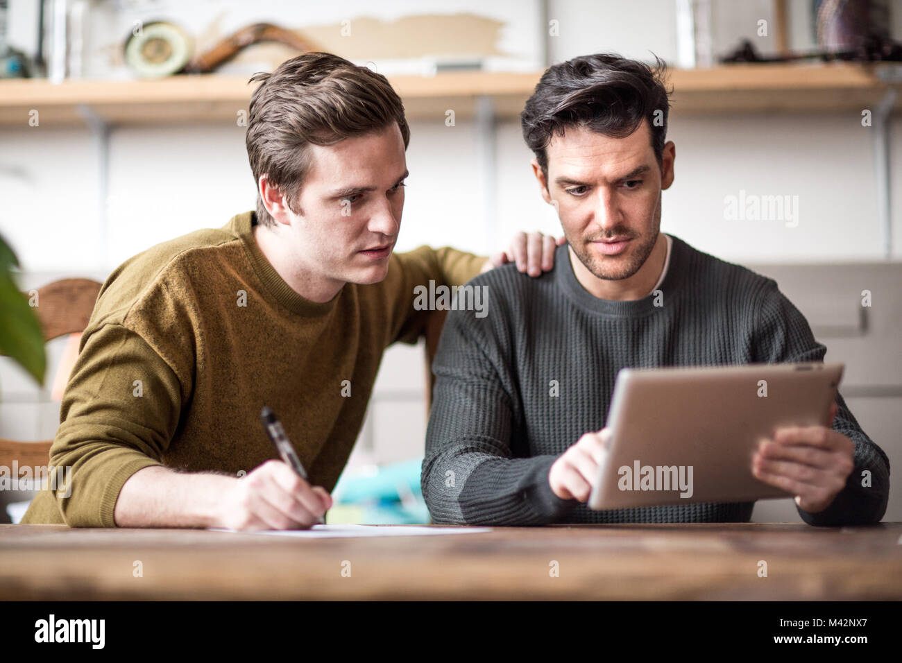 Junge männliche Paar ausfüllen Antrag auf Hypothekendarlehen Stockfoto