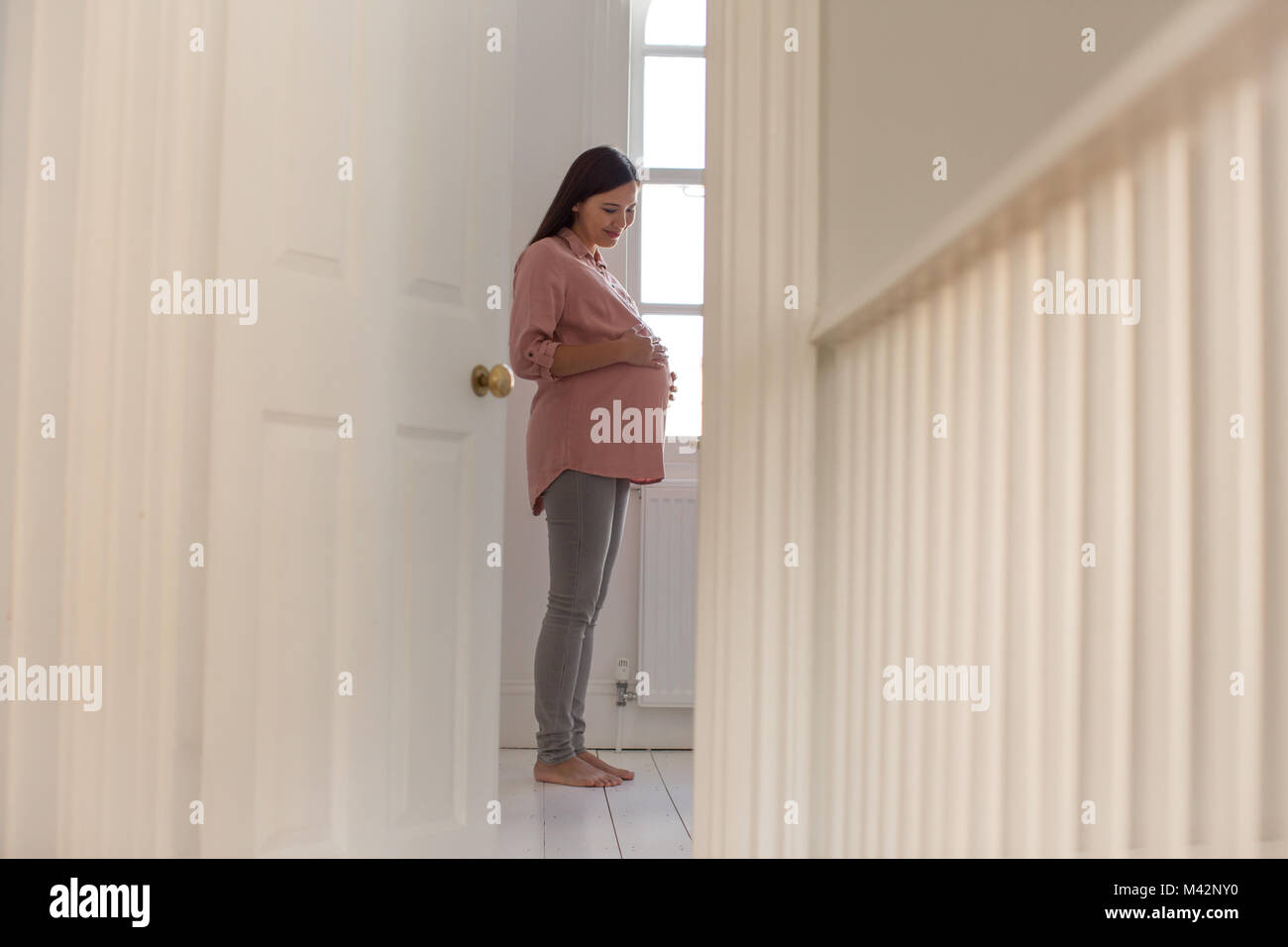 Schwangere Frau im Kinderzimmer Stockfoto