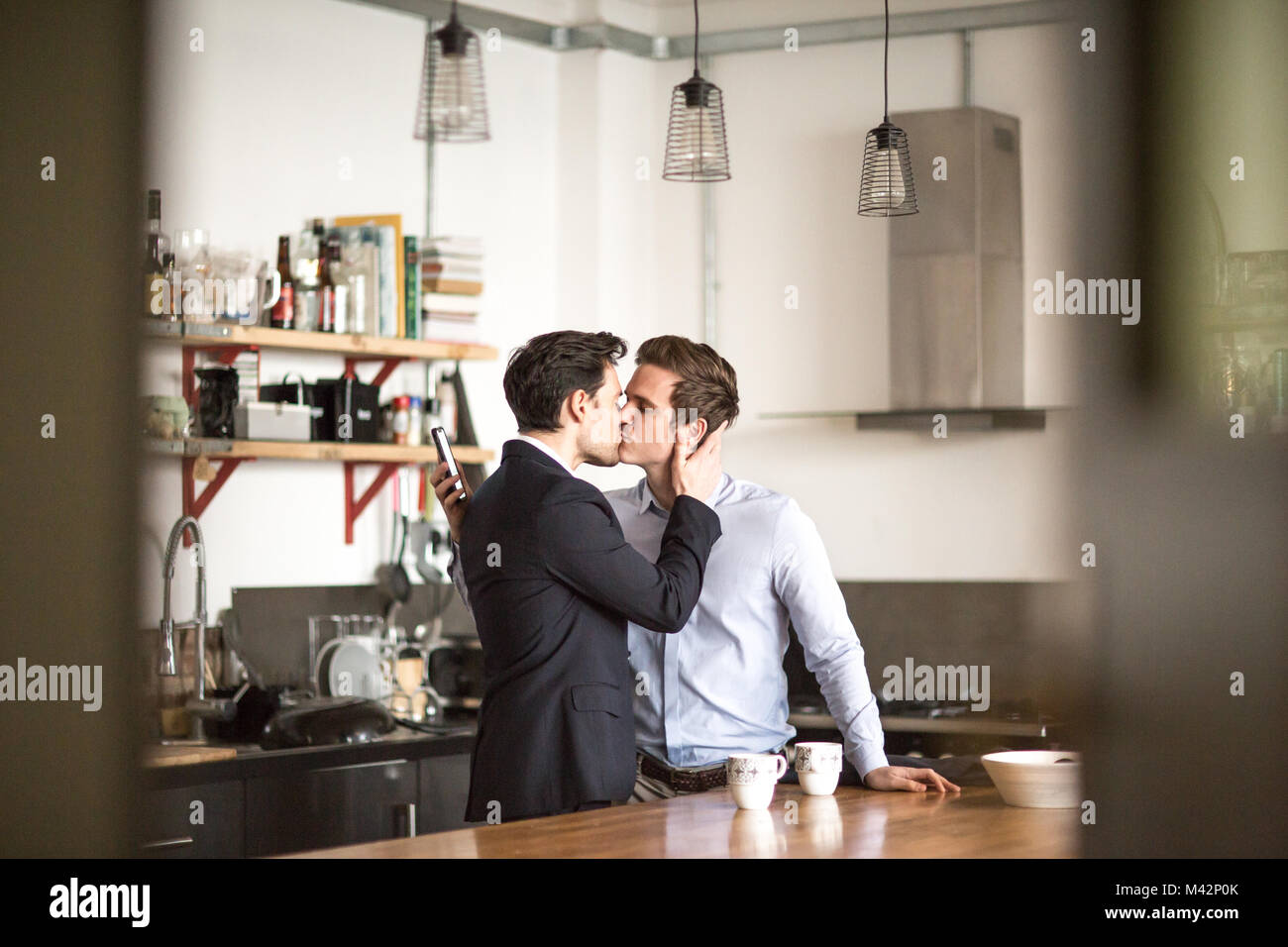 Junge männliche Paar küssen zu Hause Stockfoto