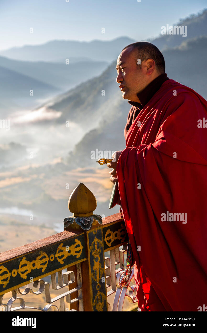 Punakha, Bhutan. Buddhistischer Mönch bei Sonnenaufgang rituelle Gebet. In seiner Hand hält er einen Vajra (Dorje) (Anbaugerät symbolisiert Mitgefühl und Stockfoto