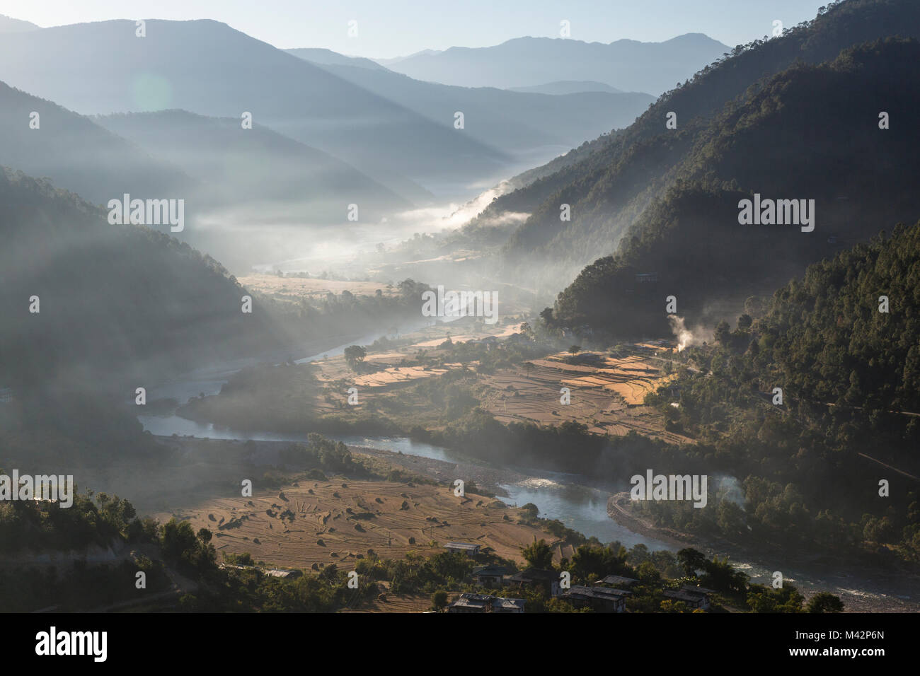 Punakha, Bhutan. Am frühen Morgen Sonne beleuchtet Morgennebel in der Mo River Valley. Stockfoto