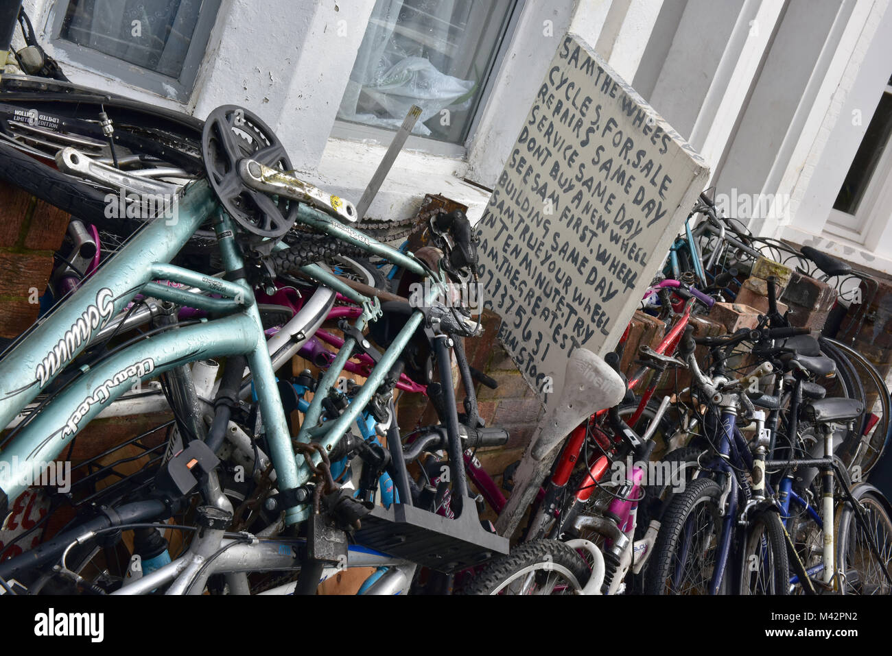 Ein Nachbar aus der Hölle mit einem Haufen Schrott Zyklus und Fahrradteile Rahmen und Räder Altmetall stapelten sich in einem Vorgarten der inländischen Wohnsitz. Stockfoto