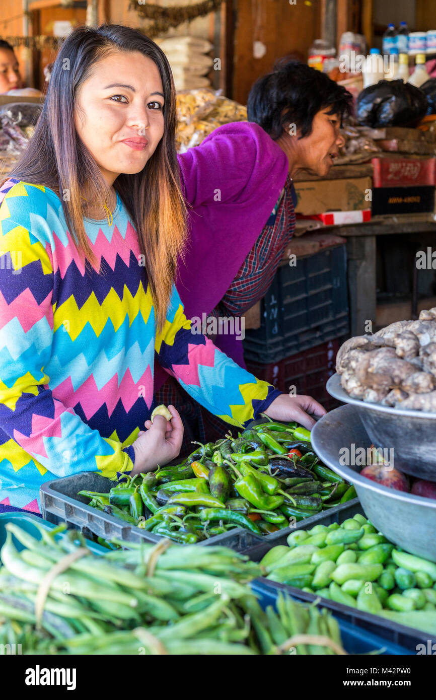 Punakha, Bhutan. Junge Frau Verkauf von Ingwer, Chilischoten, und Gemüse, Lobeysa Markt. Stockfoto