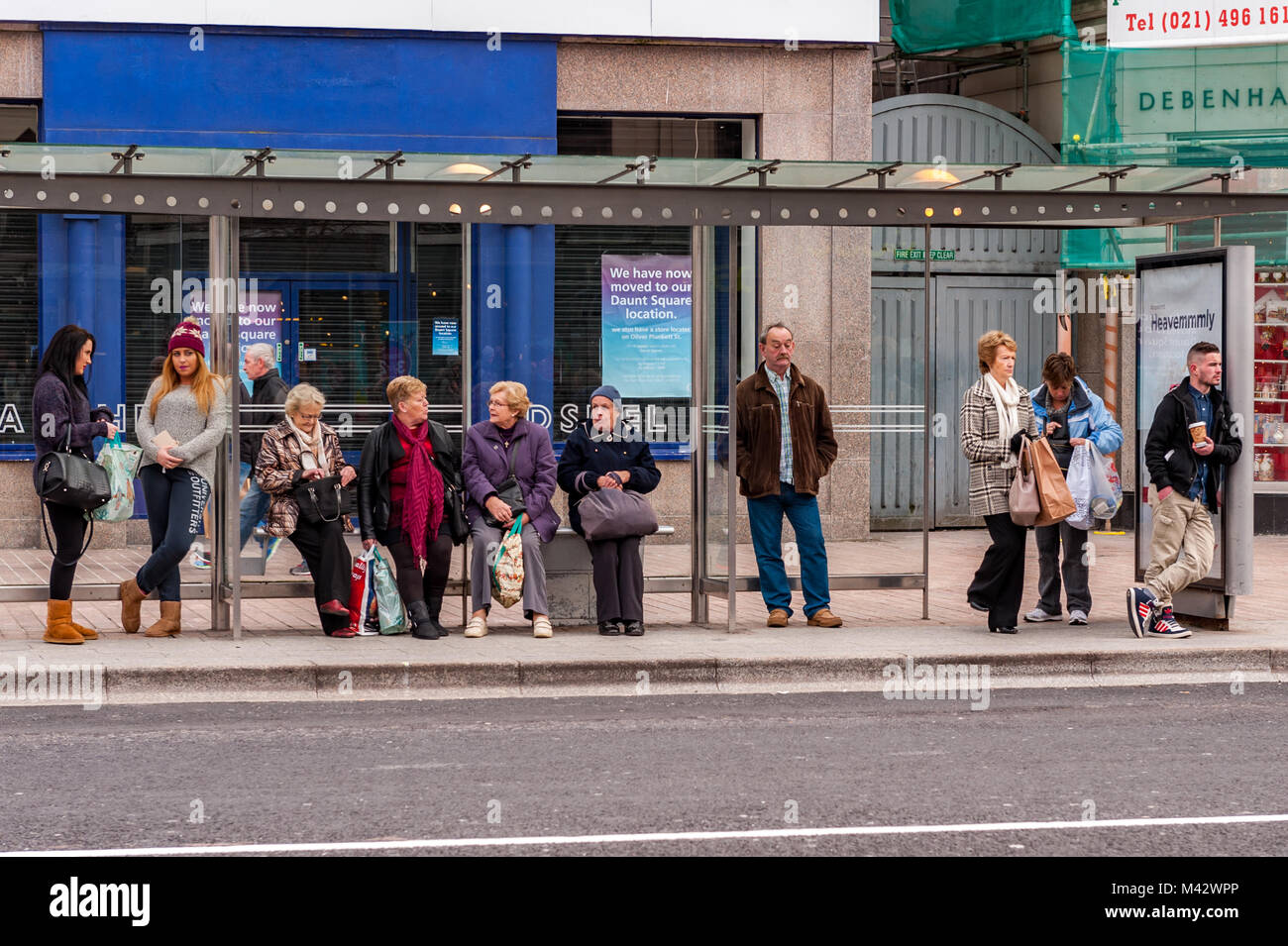 An einer Bushaltestelle im Stadtzentrum von Cork, Cork, Irland wartet. Stockfoto