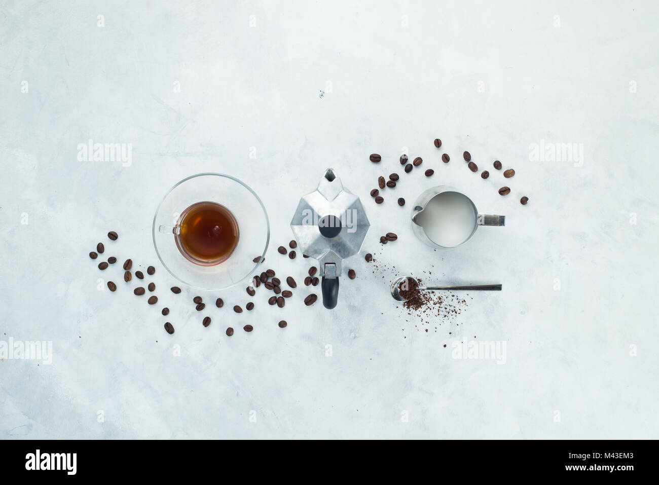 Schneidwerk mit Kaffeemaschine minimalistischen Flachbild mit Kaffeebohnen, Milch, gemahlenen Kaffee und Geysir Kaffeemaschine legen. Alternative brauen. High Key trinken Foto Stockfoto
