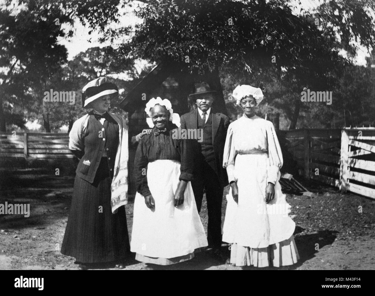 Eine Plantage landbesitzende Frau steht mit drei afrikanischen amerikanischen Arbeiter auf einem zuschneiden Baumwolle Plantage im amerikanischen Süden teilen, Ca. 1910. Stockfoto
