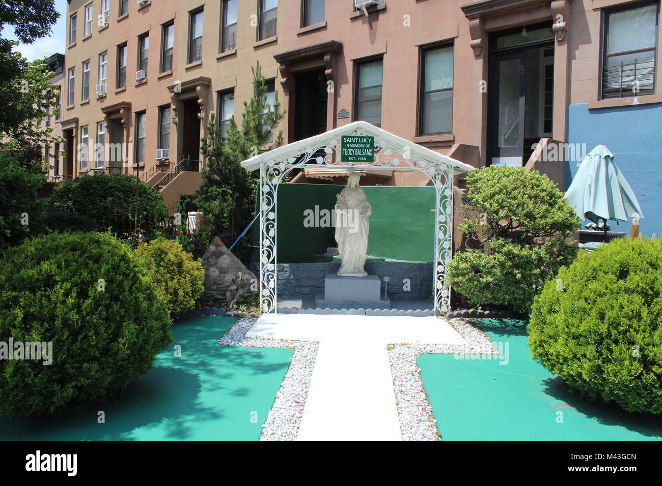 Eine steinerne Statue von Saint Lucy in seinem Vorgarten macht eine seltsame Hommage an einen verstorbenen Bewohner von Brooklyn, New York, USA Stockfoto