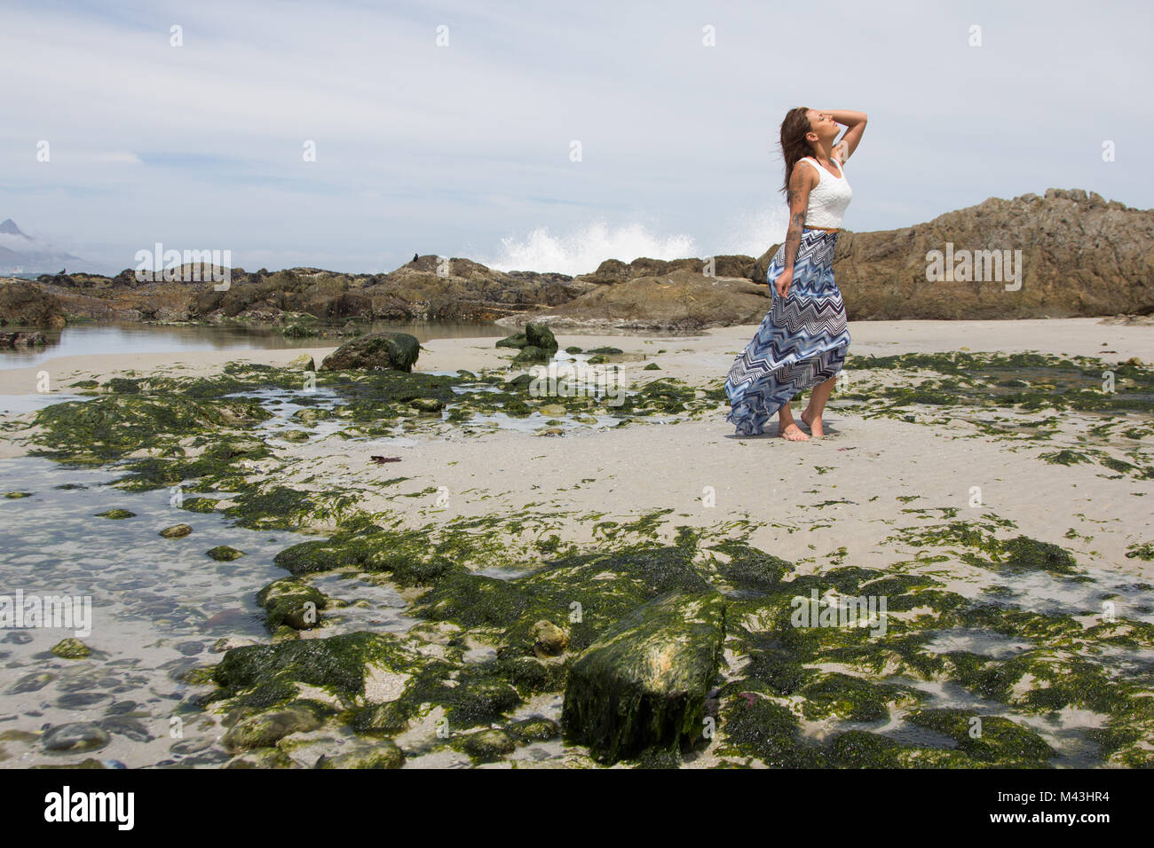 Grogeous Frau in legere Kleidung zu Fuß am Strand entlang mit Copyspace Stockfoto