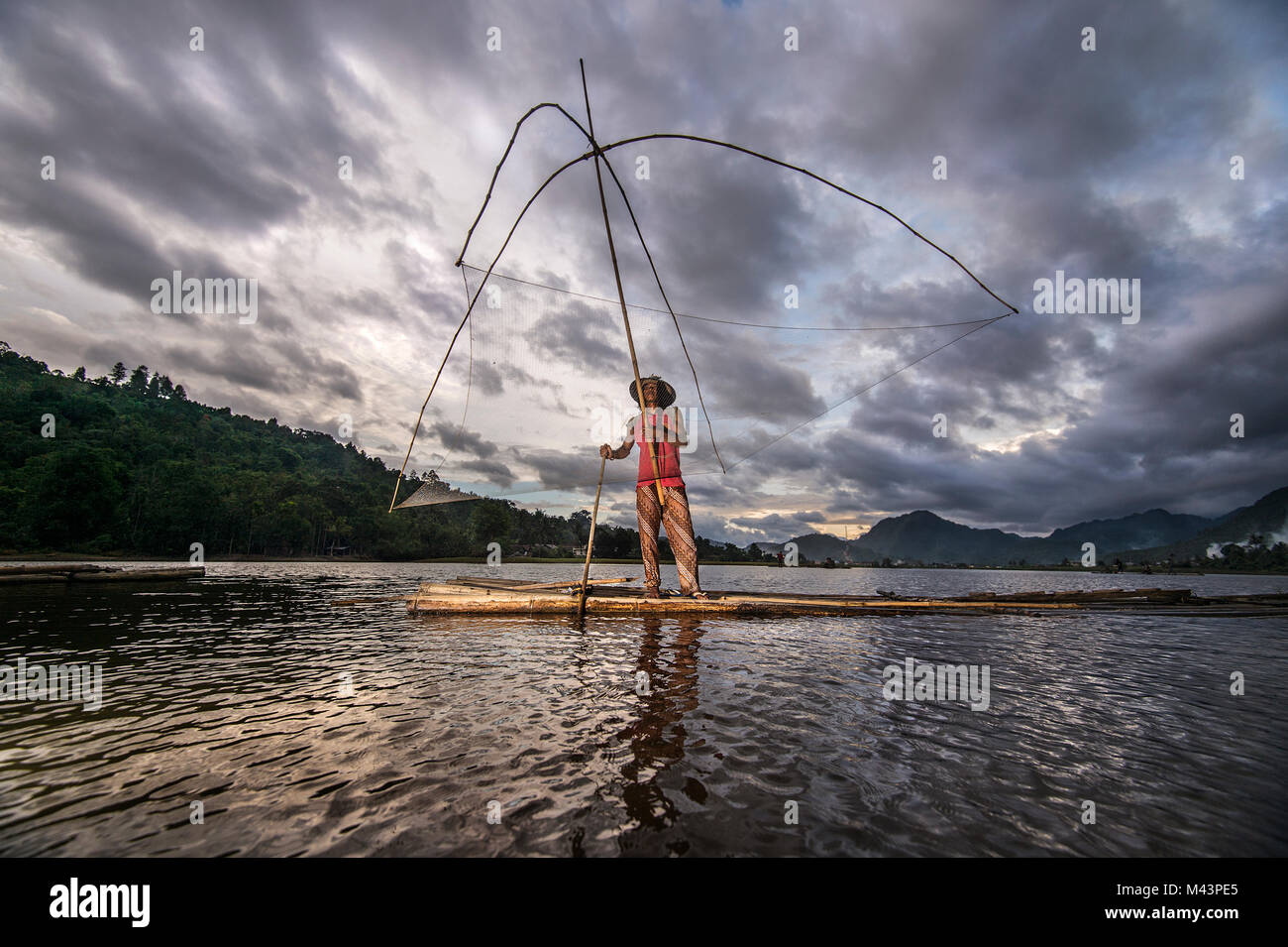Männer fangen Fische mit traditionellen Werkzeug am See. Stockfoto