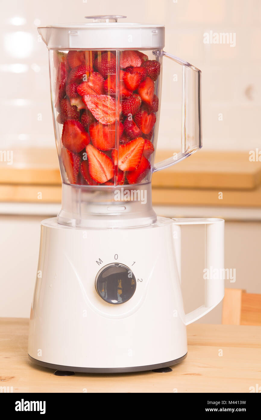 Frische Erdbeeren in weißer Blender auf einem Holztisch Stockfoto