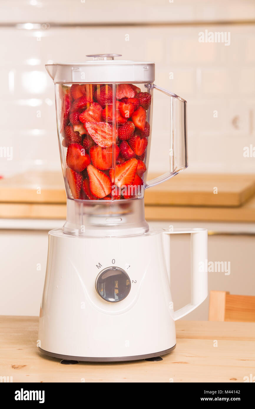 Frische Erdbeeren in weißer Blender auf einem Holztisch Stockfoto