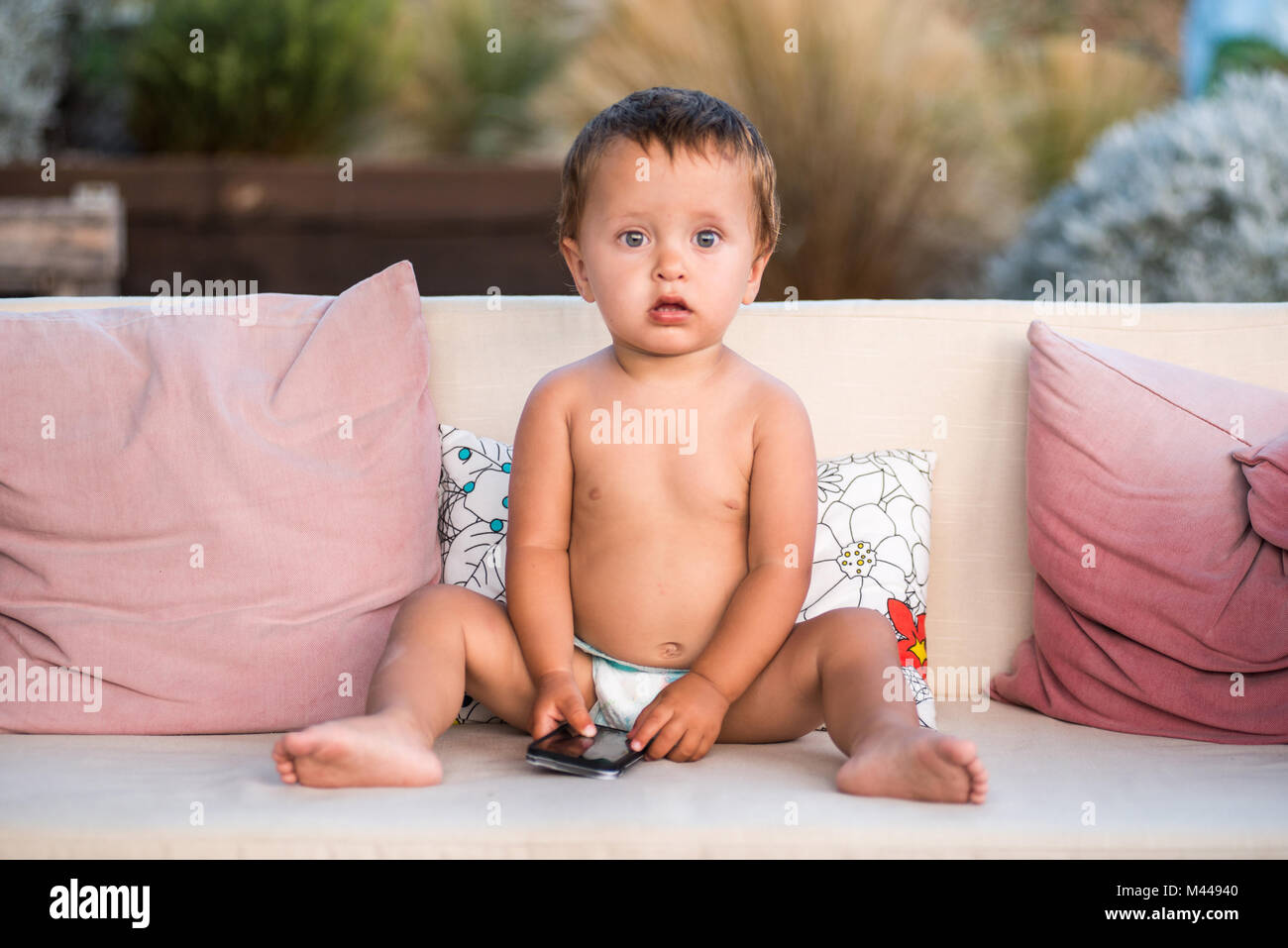 Baby Boy holding Smartphone mit Kamera suchen Stockfoto