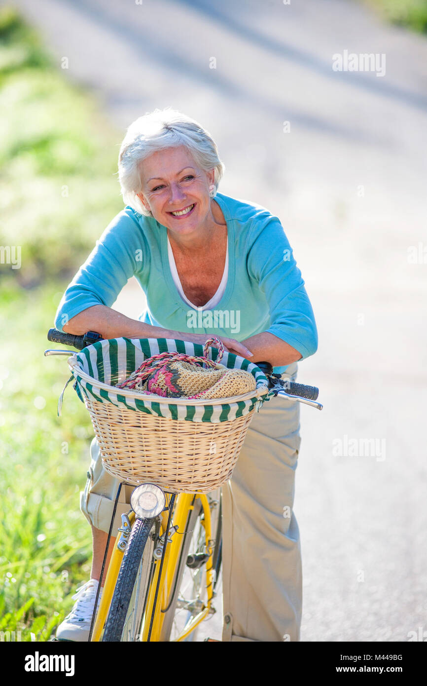 Porträt von senior Frau auf Fahrrad Stockfoto