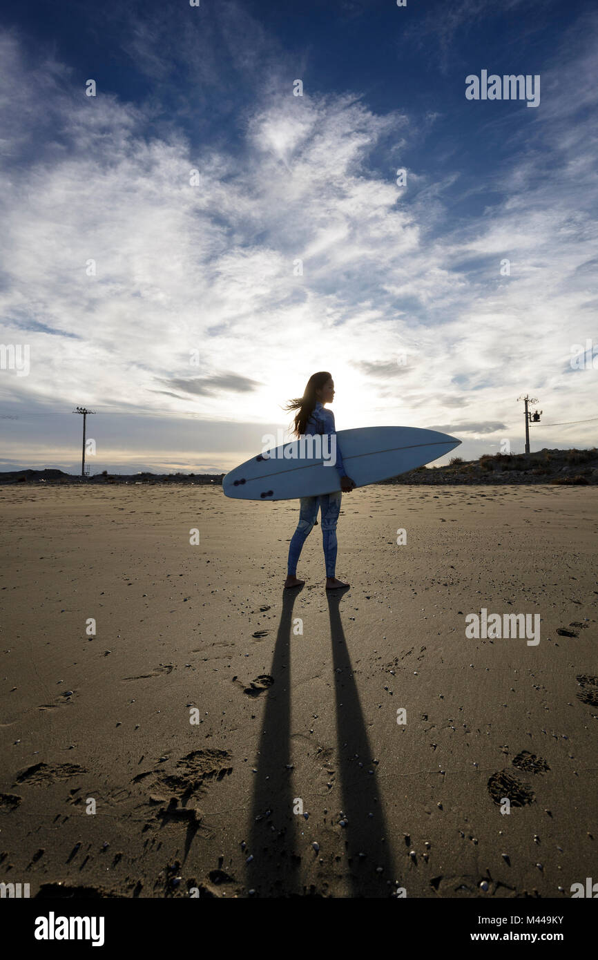 Junge weibliche Surfer am Strand, Backlit, Tarragona, Katalonien, Spanien Stockfoto