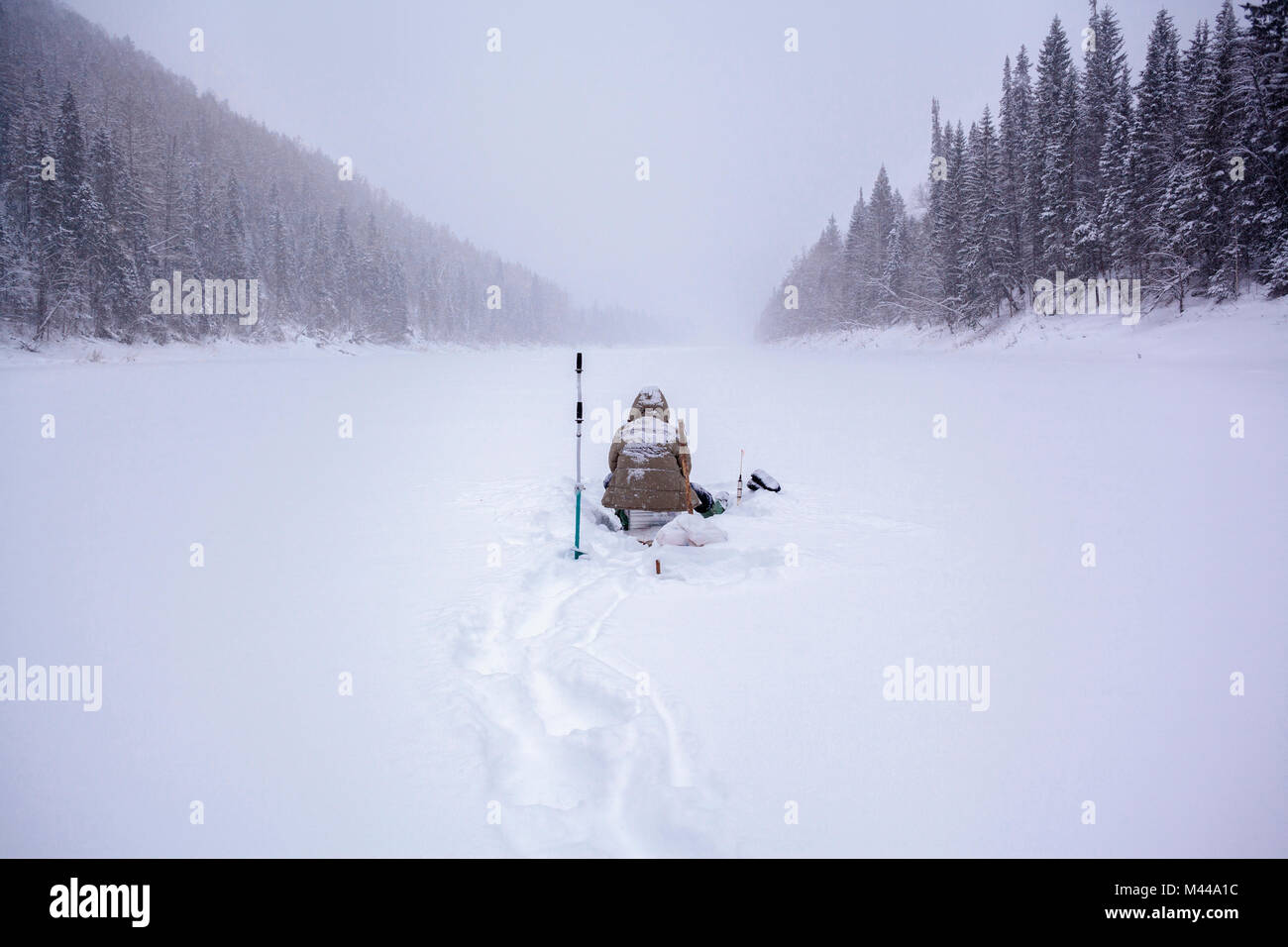 Mann sitzt bei starkem Schneefall, Ural, Sverdlovsk, Russland Stockfoto