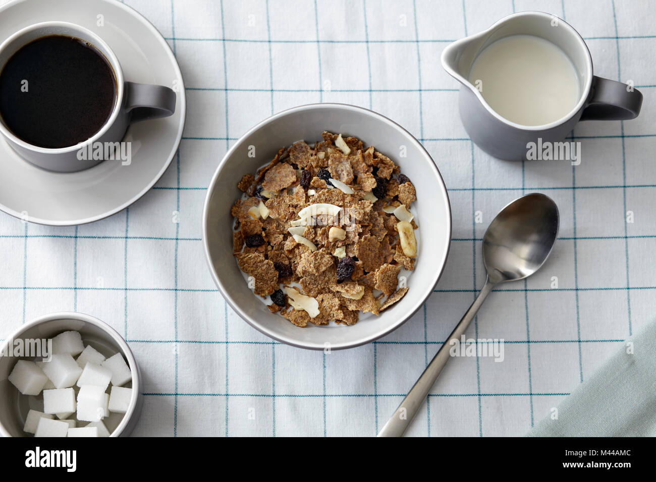 Müsli mit getrockneten Früchten, Kaffee und Milchkännchen, Ansicht von oben Stockfoto
