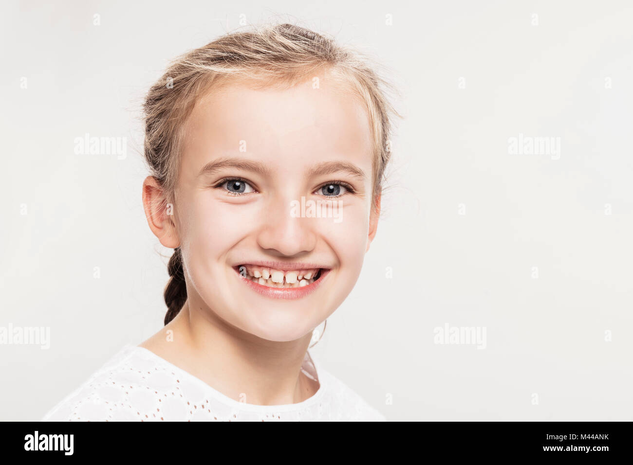 Studio Portrait von Mädchen mit toothy Lächeln, Kopf und Schultern Stockfoto