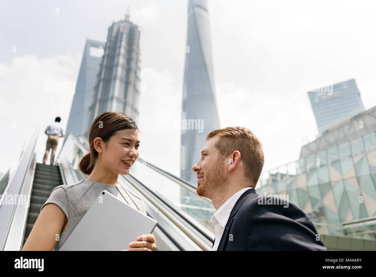Junge Unternehmer und Frau Fahrtreppe in Shanghai Financial Center, Shanghai, China Stockfoto