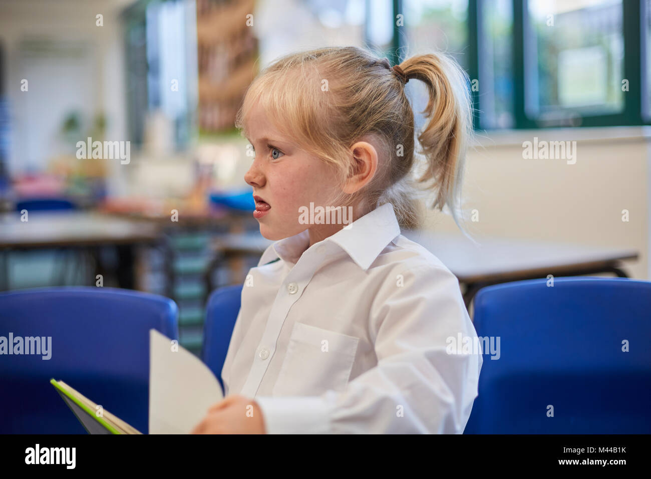 Schulmädchen ziehen ein Gesicht in der Klasse in der Grundschule Stockfoto