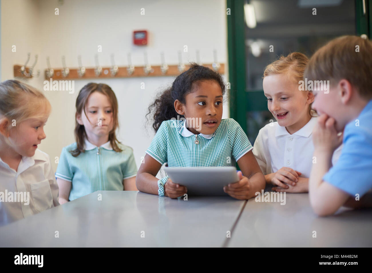 Schülerinnen und Junge mit digitalen Tablette im Klassenzimmer Unterricht in der Grundschule Stockfoto