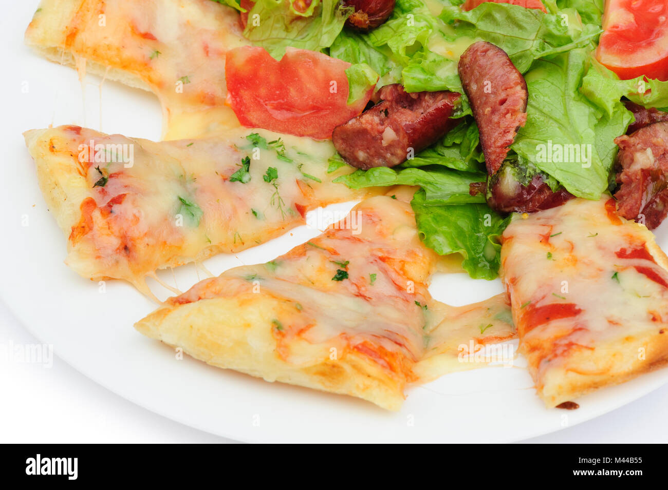 Pizzastücke und Salat Stockfoto
