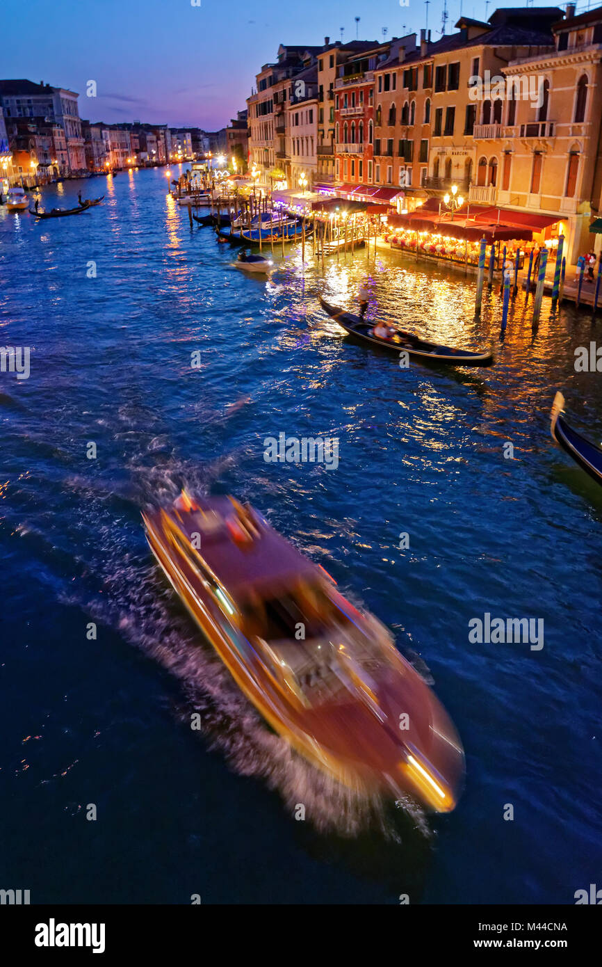 Venedig, Italien, 21. MAI 2017: Schöne Aussicht auf den Canal Grande in Venedig mit kleinen Boot überqueren Sie, Gebäude und Gondeln hinter, von der Ri gesehen Stockfoto