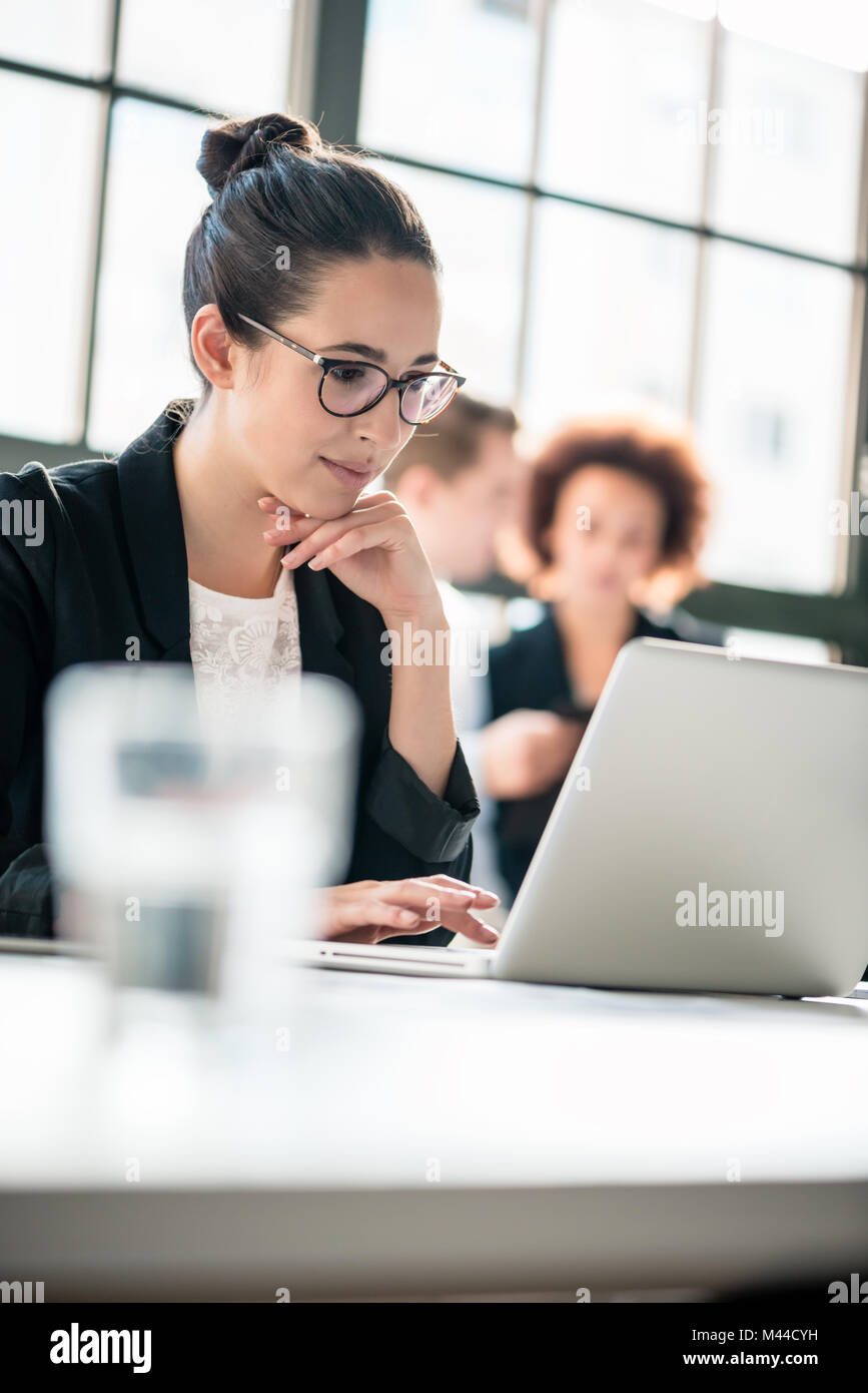 Zwei junge böswillige Mitarbeiter über ihre Kollegen tratschen Stockfoto