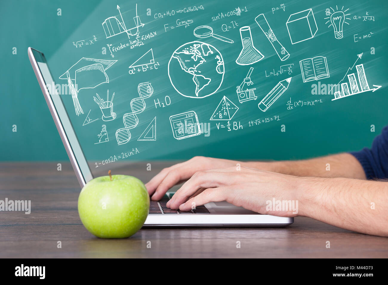 Nahaufnahme von einem Mann mit Laptop Computer mit grünem Apfel auf Schreibtisch Stockfoto