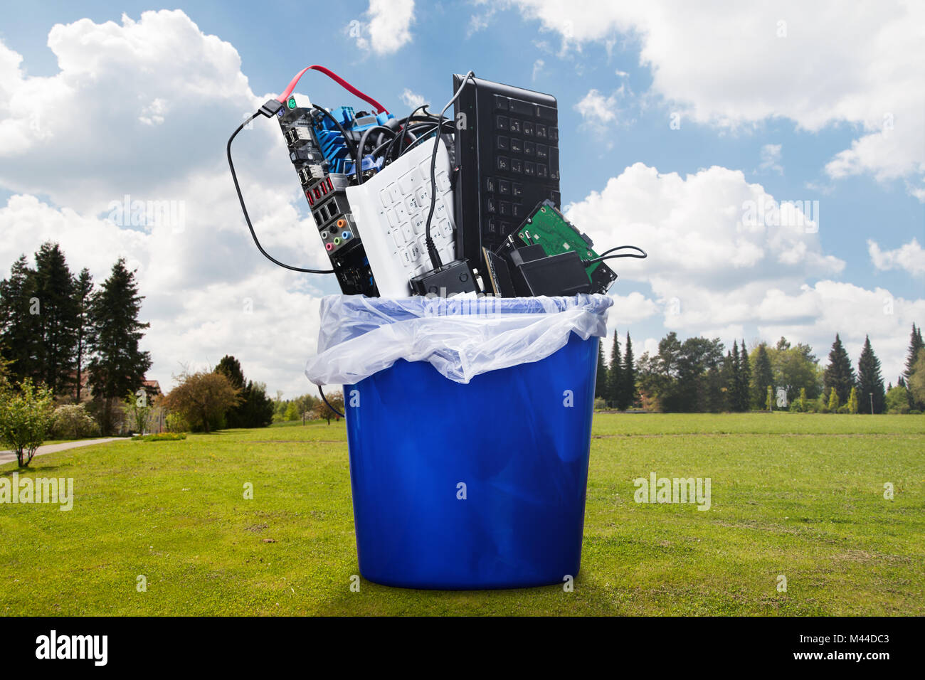 Beschädigte Hardware Ausstattung in Blau Mülltonne auf Rasen Stockfoto