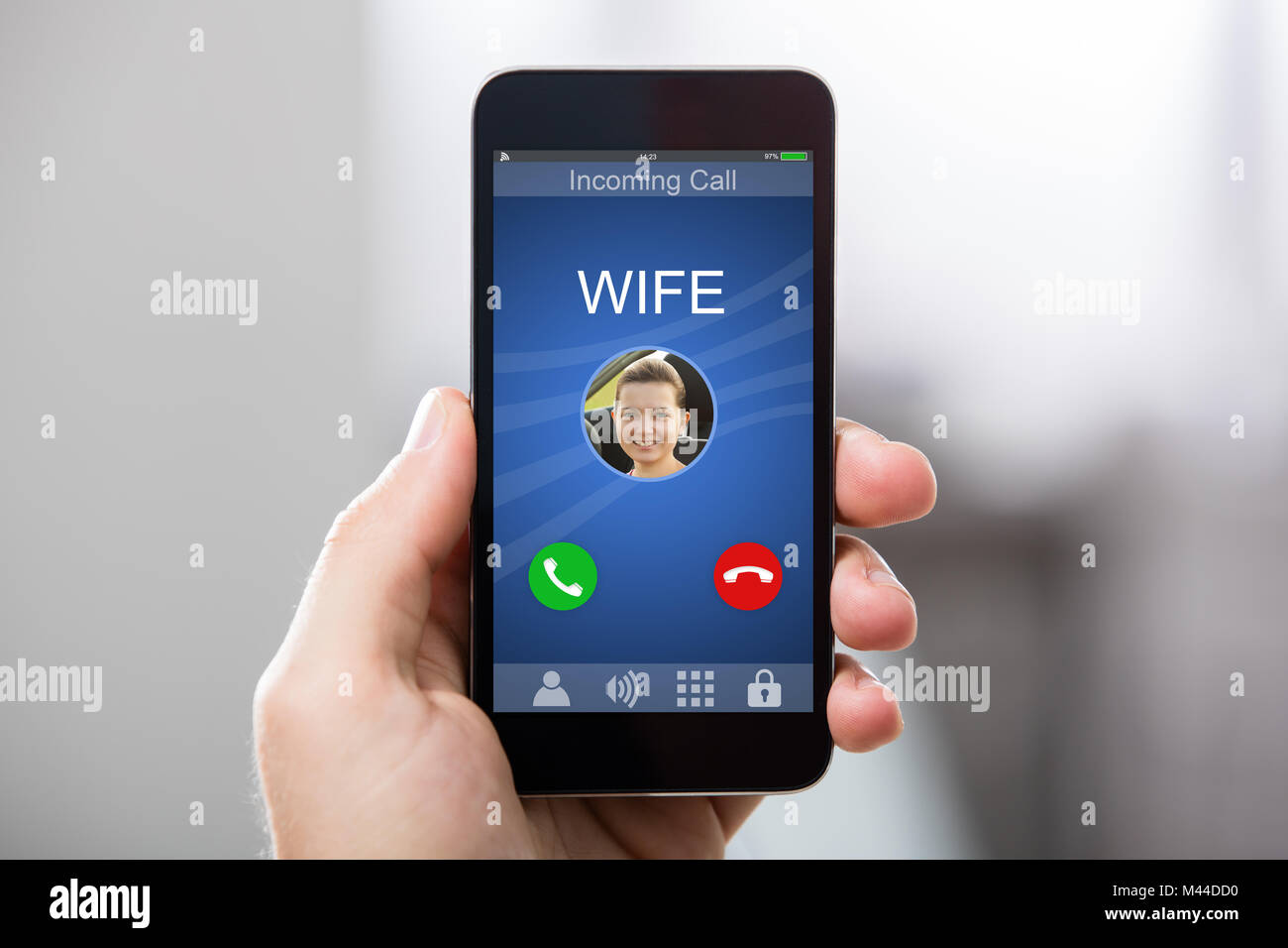 Nahaufnahme einer Hand, die Smart Phone mit der Frau des eingehenden Anrufs auf dem Display Stockfoto